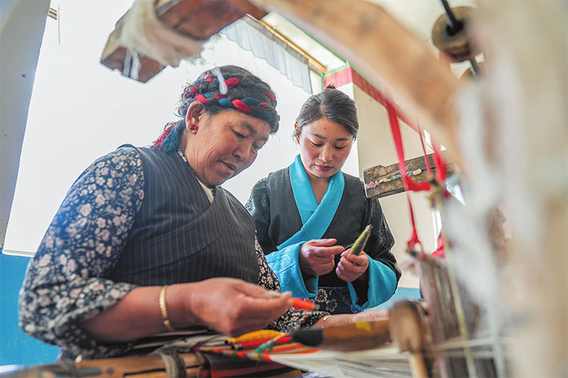 འདི་ནི་བསྟན་འཛིན་སྒྲོལ་དཀར（གཡས）གྱིས་མཉམ་ལས་ཁང་གི་ལས་མི་དང་མཉམ་དུ་པང་གདན་གྱི་བལ་སྐུད་ལ་ལྟ་བཞིན་པ།