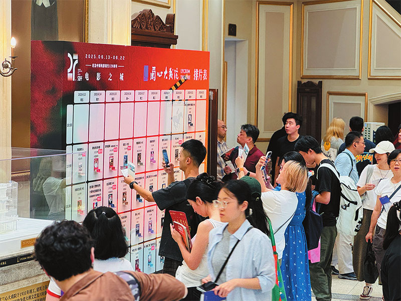 འདི་ནི་ལྟད་མོ་བས་ཧྲང་ཧའེ་ལན་ཤིང་ཟློས་གར་ཁང་ཆེན་མོར་གློག་བརྙན་སྟོན་པའི་བྱེད་སྒོར་ཞུགས་བཞིན་པ།