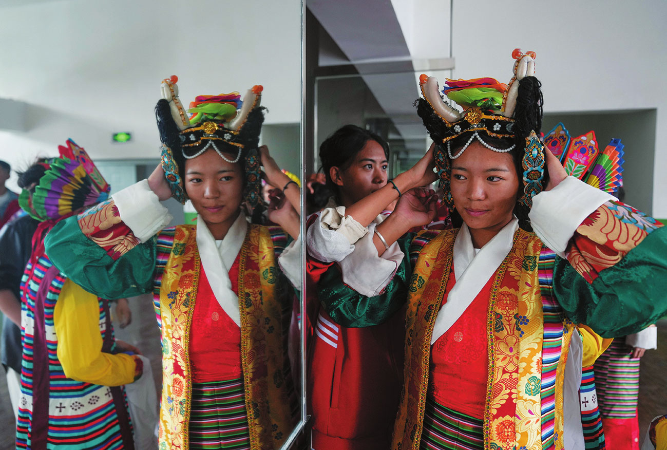 ལྷ་ས་གྲོང་ཁྱེར་འབྲིང་རིམ་ལས་རིགས་ལག་རྩལ་སློབ་གྲྭ་གཉིས་པར་སློབ་མ་ཚོས་ལྷ་མོའི་འཁྲབ་ཆས་གྱོན་བཞིན་པ།