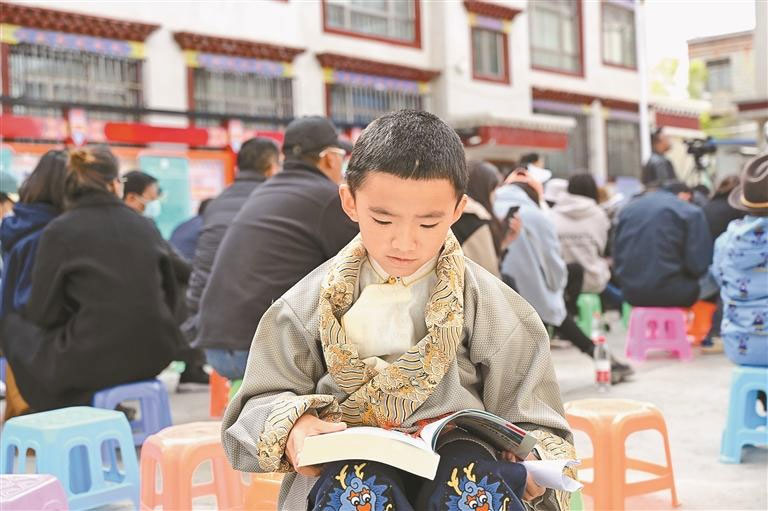 འདི་ནི་སྐྱིད་འཕེལ་སྡེ་ཁུལ་གྱི་བྱིས་པས་དཔེ་དེབ་ནན་ཏན་ངང་ལྟ་བཞིན་པ།