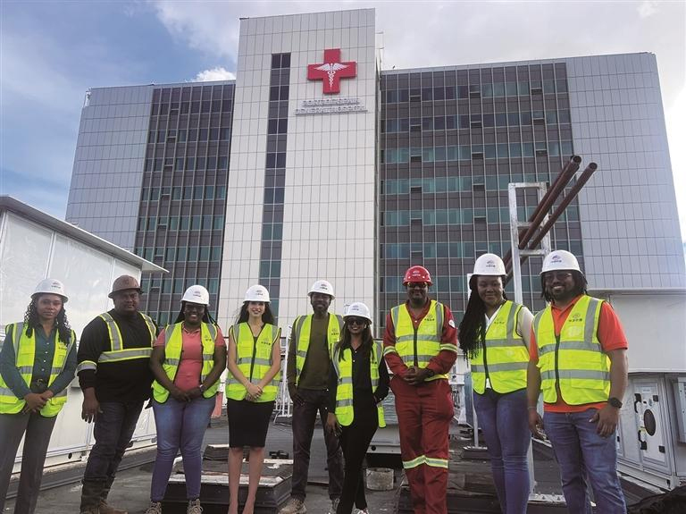 འདི་ནི་ཧྲ་ལཱ（གཡོན་གྱི་གསུམ་པ）ཡིས་ས་གནས་དེ་གའི་ལས་རོགས་དང་མཉམ་དུ་ཀྲུང་གོའི་ཁེ་ལས་ཀྱིས་སྐྲུན་འགན་འཁུར་བའི་སི་ཕེན་གྲུ་ཁ་སྤྱི་ཁྱབ་སྨན་ཁང་གི་ལྟེ་བའི་བ་གམ་གྱི་མདུན་དུ་མཉམ་པར་རྒྱག་བཞིན་པ།