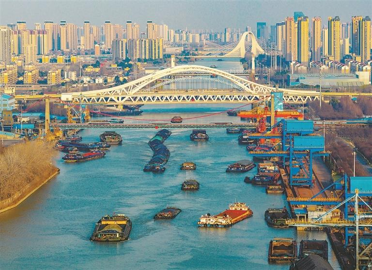 ཅིང་ཧང་མིས་བཟོས་གཙང་པོར་རྡོ་སོལ་དང་། ཞིང་སྤྱོད་རྒྱུ་ཆ། ཨར་ལས་རྒྱུ་ཆ་སོགས་དངོས་ཟོག་སྣ་ཚོགས་བླུགས་པའི་ཟོག་འདྲེན་གྲུ་གཟིངས་ཕར་འགྲོ་ཚུར་འོང་བྱས་ནས་བྲེལ་བརྩོན་གྱི་རྣམ་པས་ཁེངས་ཤིང་། འདི་ནི་ཅིང་ཧང་མིས་བཟོས་གཙང་པོའི་ཅང་སུའུ་ཧོའེ་ཨན་དུམ་བུར་སྐྱོད་བཞིན་པའི་གྲུ་གཟིངས་ཡིན་པ།