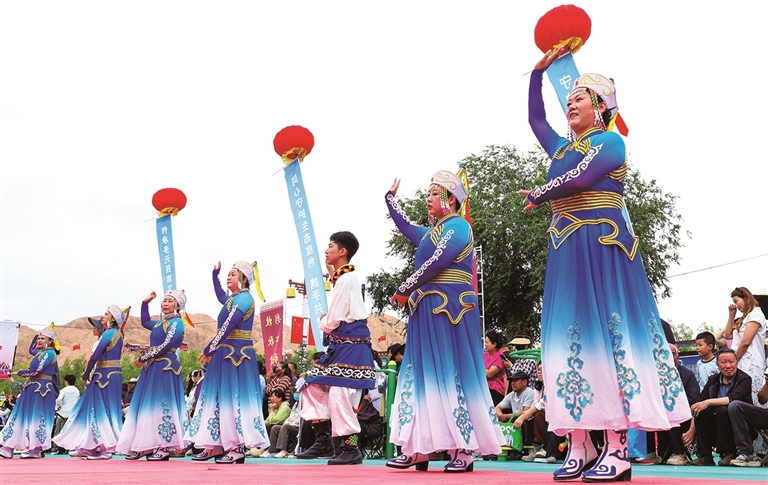 འདི་ནི་ཀན་སུའུ་ཞིང་ཆེན་ཀྲང་ཡེ་གྲོང་ཁྱེར་སུའུ་ནན་ཡུས་ཀུའུ་རིགས་རང་སྐྱོང་རྫོང་གདོང་སྣ་བོད་རིགས་ཤང་གི་ཝུན་ཧུའེ་ཐང་ཆེན་དུ་ཞིང་འབྲོག་མང་ཚོགས་ཀྱིས་མི་རིགས་ཀྱི་ཁྱད་ཆོས་ལྡན་པའི་གླུ་གར་འཁྲབ་སྟོན་བྱེད་བཞིན་པ།